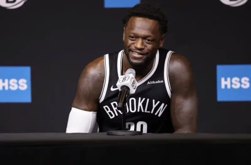 A Basketball Player in a Brooklyn Nets Jersey at a Press Conference