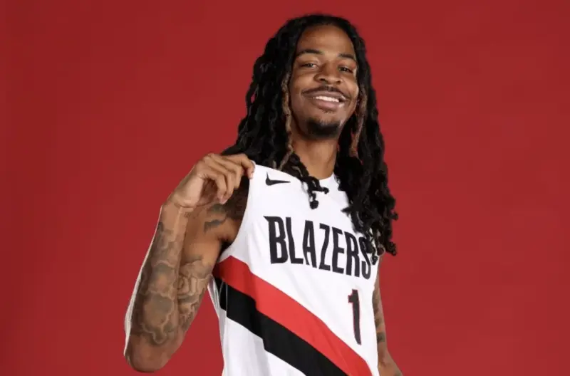 A Basketball Player Holds a Portland Trail Blazers Jersey